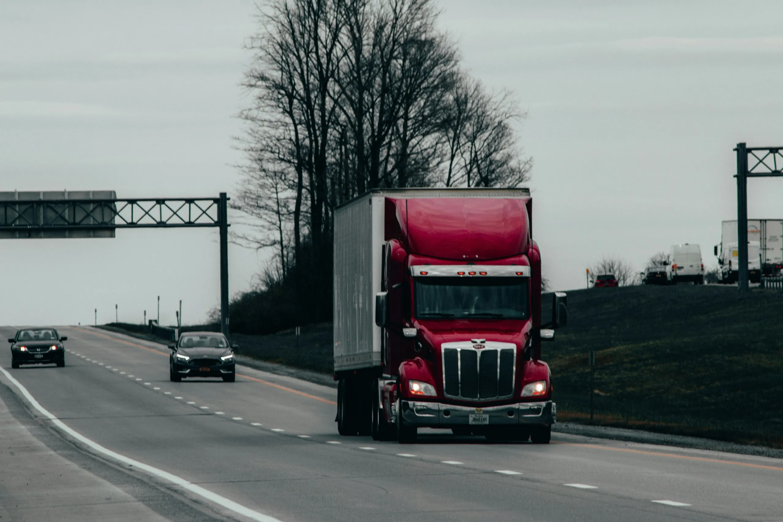 Red tractor-trailer driving on a highway