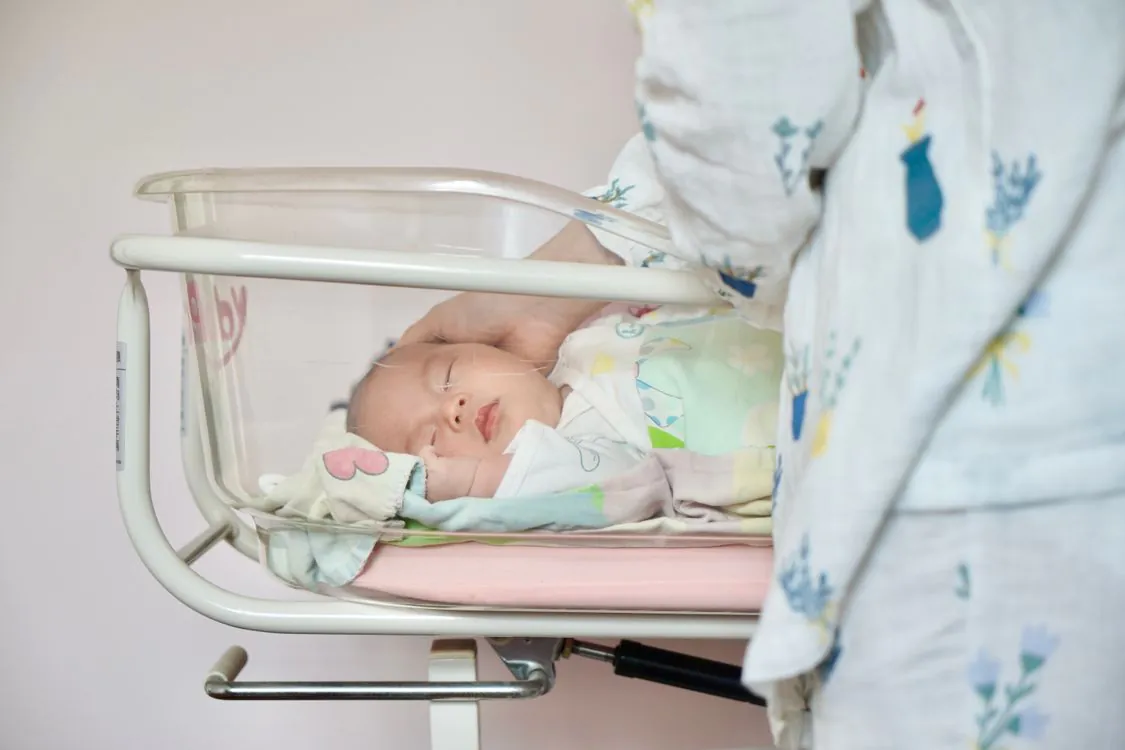 Newborn baby sleeping in a hospital bassinet