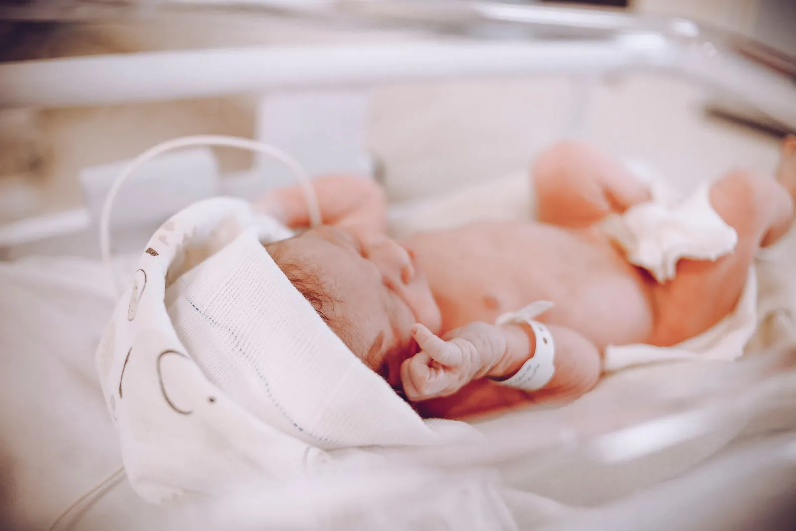 Newborn baby swaddled in a blanket in a hospital crib