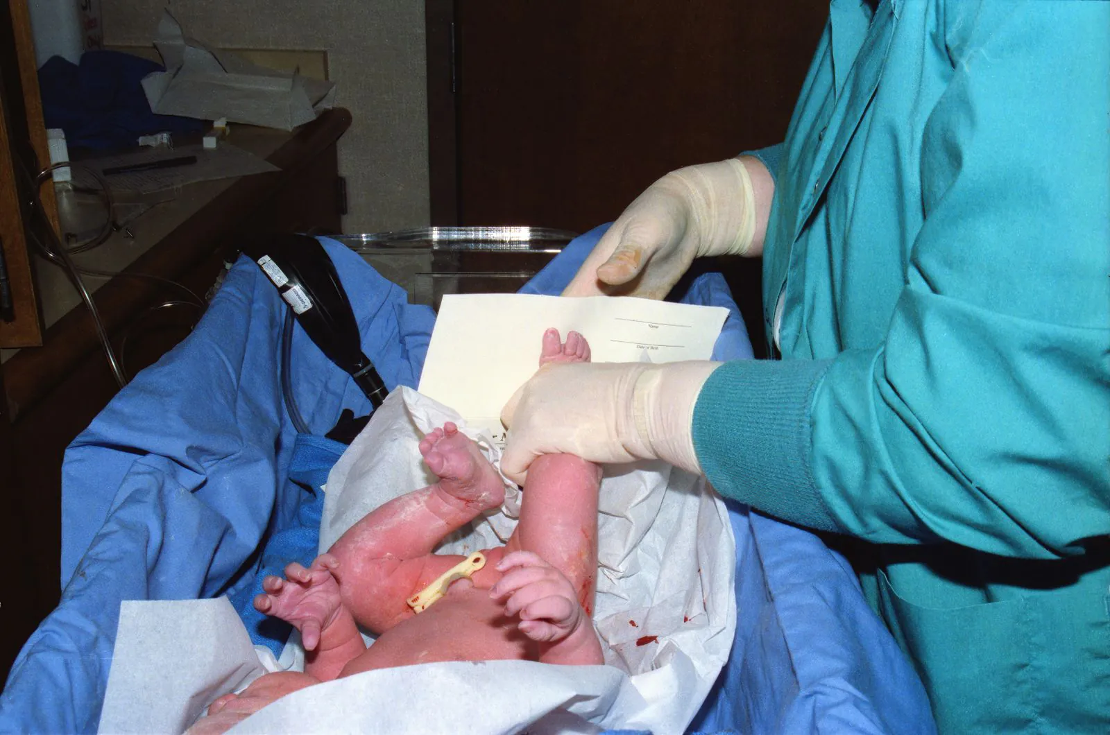 Newborn baby receiving care from a nurse in a hospital delivery room